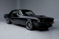 a black muscle car parked in a dark room