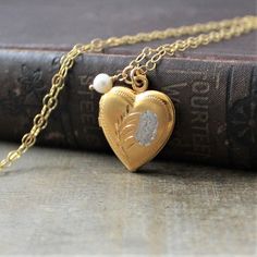 "This vintage locket is engraved with a floral design on the front; the reverse is plain. The gold filled heart opens revealing two compartments in which to place your favorite photos. The locket hangs from a new 14k gold filled cable chain accented with tiny freshwater pearl and finished with a lobster clasp. Locket 24x20mm Necklace length 18\" (45cm) ✦All of our vintage lockets ship with complimentary insurance✦ ✤Our entire selection of lockets can be found here✤ http://www.etsy.com/shop/Lexia Traditional Yellow Gold Keepsake Jewelry, Traditional Yellow Gold Jewelry For Keepsake, Vintage Necklace With Engraving Option For Keepsake, Traditional Gold Keepsake Jewelry, Antique Gold Heart Charm Jewelry For Anniversary, Antique Gold Jewelry With Heart Charm For Anniversary, Yellow Gold Wedding Jewelry With Engraving Option, Vintage Etched Jewelry For Marriage, Vintage Necklaces With Engraving Option For Anniversary