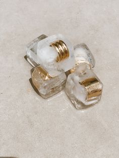 three ice cubes sitting on top of a white counter next to each other with gold rings