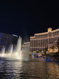 the fountains in front of the hotel are lit up at night