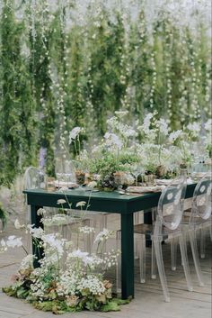 an outdoor table with chairs and flowers on it