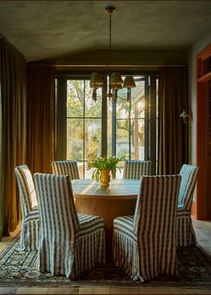 a dining room table with chairs and a rug on the floor in front of it