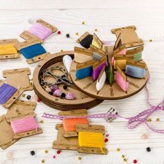 craft supplies are laid out on a white wooden table with beads and ribbons around them