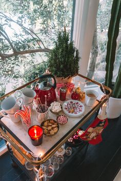 a tray filled with cookies and candy on top of a table next to a window