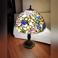 a stained glass lamp sitting on top of a wooden floor