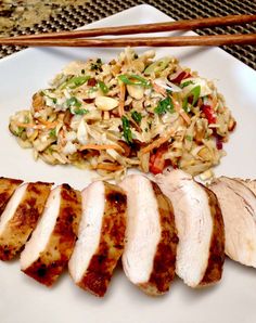 a white plate topped with sliced chicken and rice