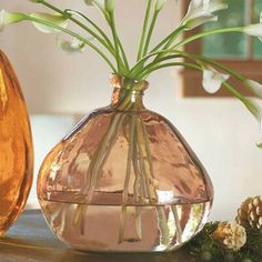 two vases with flowers in them sitting on a table