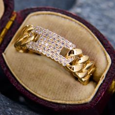 an open box with a gold ring and diamond set in it's center, sitting on top of a table