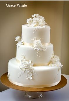 a three tiered cake with white flowers on it