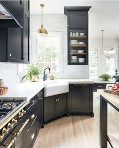 an image of a kitchen setting with black cabinets and white counter tops, gold accents