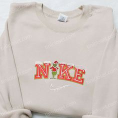 The Grinch Snow x Nike Embroidered Shirt is the perfect blend of style and holiday spirit. Made with high-quality materials, this shirt features an intricately embroidered Grinch design, adding a festive touch to any outfit. Its comfortable fit and durable construction ensure long-lasting wear. Give your loved ones the gift of warmth and style this Christmas with our Christmas Embroidered Sweatshirt. Crafted with care, this sweatshirt features a unique holiday-themed embroidery that will make a statement wherever you go. Made with soft and cozy fabric, it offers both comfort and style, making it an ideal gift for family members. Whether Nike Cartoon, Nike Inspired, Best Family Gifts, Maroon Hoodie, Hoodie Material, Nike Sweatshirts, Custom Nikes, Embroidered Clothes, Embroidered Sweatshirt