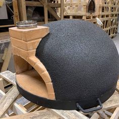 a large black object sitting on top of wooden pallets