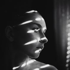 black and white photo of woman with light shining through her eyes