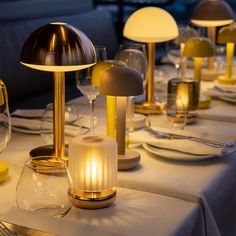 the table is set with many different types of lights and dishes, including wine glasses