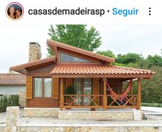 a small wooden house with a hammock on the porch