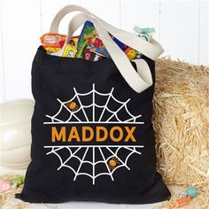 a black bag with the word maddox on it sitting next to some candy