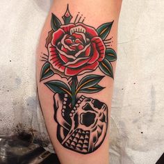 a skull and rose tattoo on the leg