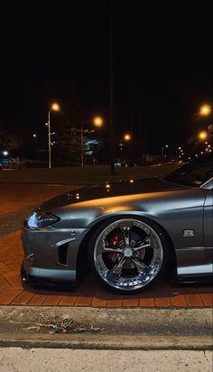 a silver sports car parked on the street at night