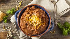 a bowl of chili dip with cheese on top