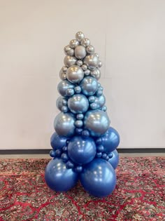 blue and silver balloons are stacked on top of each other in the shape of a christmas tree