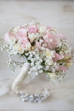 a bridal bouquet with pink roses and baby's breath