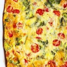 a casserole with tomatoes, spinach and cheese