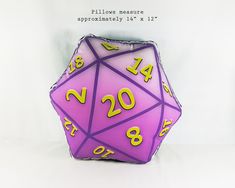 a purple and yellow d20 dice with numbers on the side, sitting in front of a white background