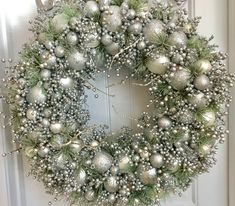 a christmas wreath with silver and white ornaments