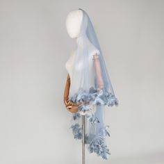 a mannequin wearing a blue veil with flowers on it