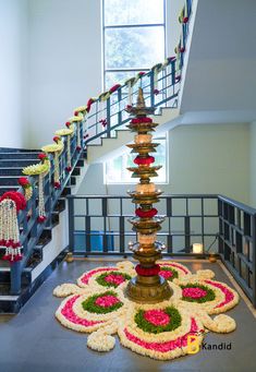 an elaborately decorated fountain in the middle of a building with flowers and garlands around it