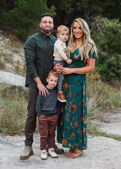 a family posing for a photo in front of some trees