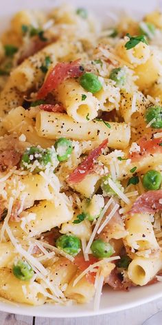 a pasta dish with peas, ham and parmesan sprinkles on top