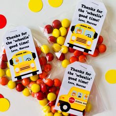 two bags filled with candy sitting on top of a table next to yellow and red candies