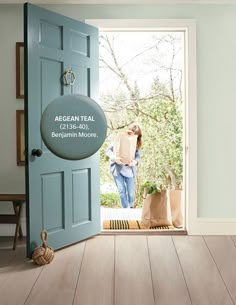 an open door with the words aegean teal on it and a woman holding a bag