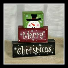 three christmas blocks stacked on top of each other with a snowman in the middle