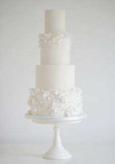 a three tiered cake with white flowers on top