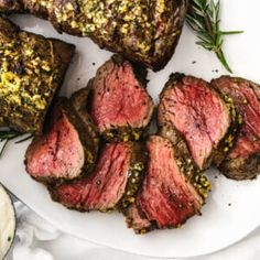 sliced steak on a plate with herbs and seasoning