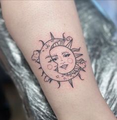 a small sun and moon tattoo on the arm