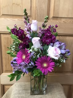 a vase filled with purple and white flowers