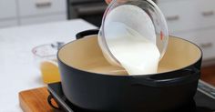 a person pouring milk into a skillet