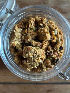 a glass bowl filled with granola and nuts on top of a wooden countertop