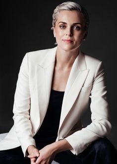 a woman in a white jacket sitting down