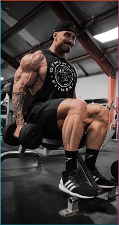 a man sitting on top of a bench in a gym