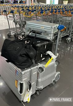 luggage carts are lined up in an airport with many bags on the top one cart