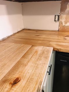 an unfinished kitchen counter top with a black dishwasher