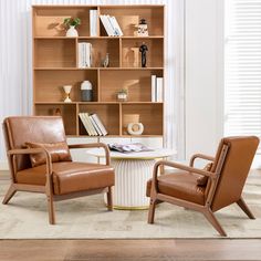 two chairs and a table in front of a book shelf with books on it's shelves