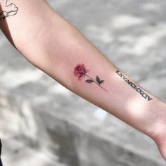 a woman's arm with a rose tattoo on it