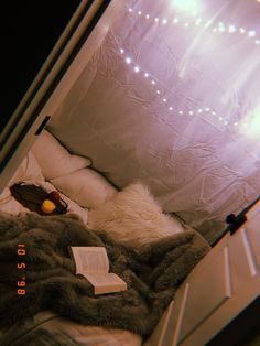 an unmade bed with a book and stuffed animal