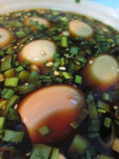 a bowl filled with broth and vegetables on top of a table