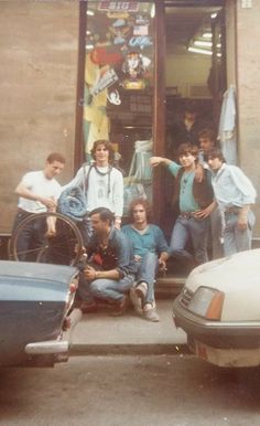 a group of young men standing next to each other in front of a store